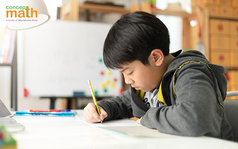 Student wearing grey jacket very focused on studying